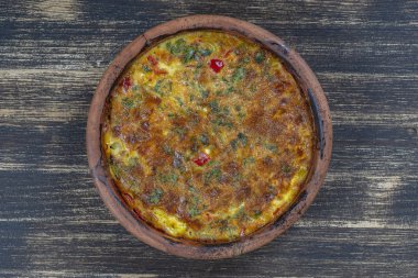 Sebze frittata, basit vejetaryen gıda ile Seramik kase. Ahşap masa üzerinde domates, biber, soğan ve peynir ile Frittata, yakın. İtalyan yumurtalı omlet