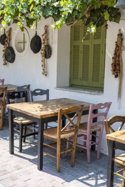 Küçük kafe dış ön görünümü. Masa ve boş sandalyeler beyaz duvarın yanında açık havada. Turistik yerler. Tipik Akdeniz restoranı, yaz aylarında bir yer tatil