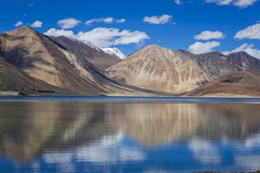 Hint Himalayalar, Ladakh bölgesi, Hindistan mavi gökyüzü ve göl Pangong karşı görkemli kayalık dağların görünümü. Doğa ve seyahat konsepti