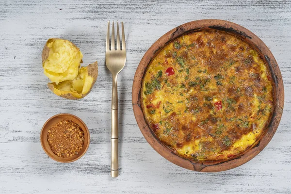 Ciotola in ceramica con frittata di verdure, semplice cibo vegetariano. Frittata con pomodoro, pepe, cipolla e formaggio sul tavolo di legno, da vicino. frittata di uova italiane — Foto Stock