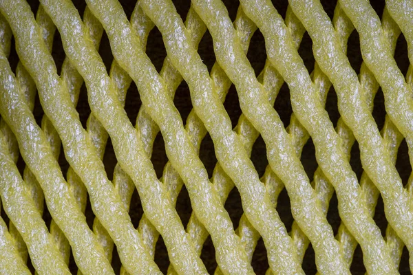 Abstract background of yellow plastic mesh texture for fruit, close up — Stock Photo, Image