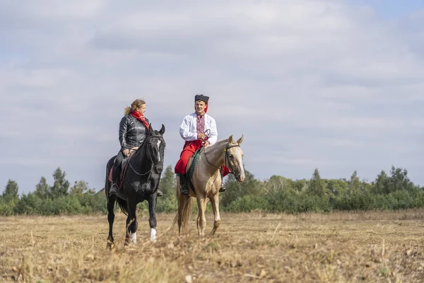 Ukrainian guy and girl on horseback participate in the Ethno-eco festival Kolodar in city Slavuta, Ukraine — Stock Photo, Image