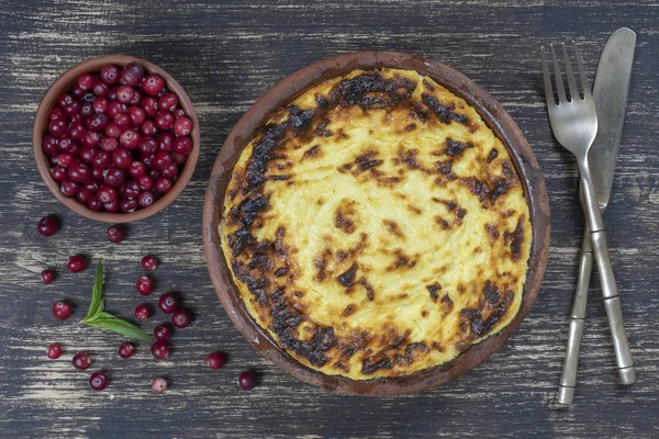 Casseruola di fiocchi di latte dolci con uvetta e semola sul tavolo di legno. Ciotola in ceramica con casseruola di fiocchi di latte al forno, primo piano, vista dall'alto — Foto Stock