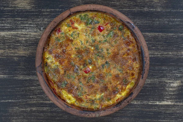 Ciotola in ceramica con frittata di verdure, semplice cibo vegetariano. Frittata con pomodoro, pepe, cipolla e formaggio sul tavolo di legno, da vicino. frittata di uova italiane — Foto Stock