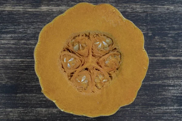 Abóbora amarela cortada ao meio com a textura de sementes e polpa. Fatias de abóbora fundo closeup, vista superior — Fotografia de Stock