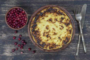 Ahşap masada kuru üzüm ve irmik ile Tatlı süzme peynir güveç. Fırında süzme peynir güveç ile Seramik kase , closeup, üst görünümü
