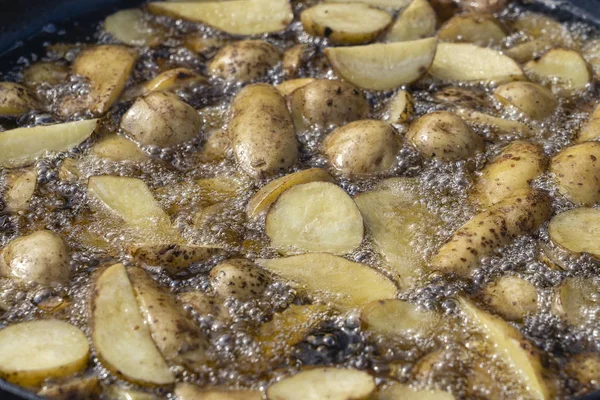 Gebakken aardappelen in een grote pan. Jonge aardappelen worden gebakken in olie, Street Food — Stockfoto