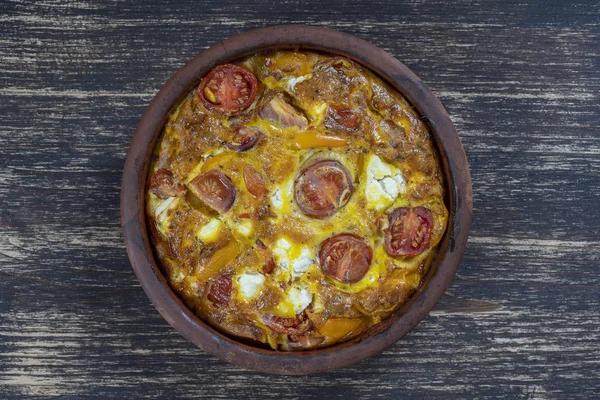 Ciotola in ceramica con frittata di verdure, semplice cibo vegetariano. Frittata con pomodoro, pepe, cipolla e formaggio feta sul tavolo di legno, da vicino. frittata di uova italiane — Foto Stock