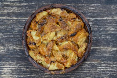 Fırında patates ve havuç tahta masada peynir ile, yakın. Patates ve havuç dilimleri arka plan ile Seramik kase