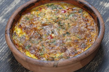 Sebze frittata, basit vejetaryen gıda ile Seramik kase. Ahşap masa üzerinde domates, biber, soğan ve peynir ile Frittata, yakın. İtalyan yumurtalı omlet