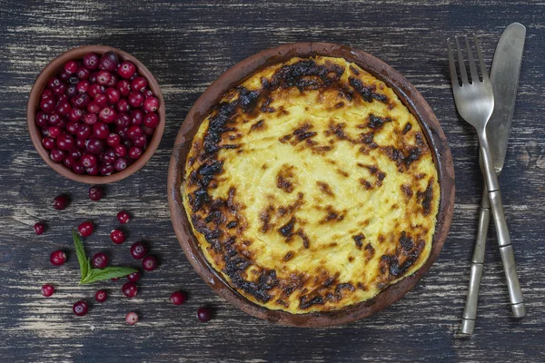 Sweet Cottage Cheese braadpan met rozijnen en griesmeel op houten tafel. Keramische kom met gebakken kwark braadpan, close-up, bovenaanzicht — Stockfoto