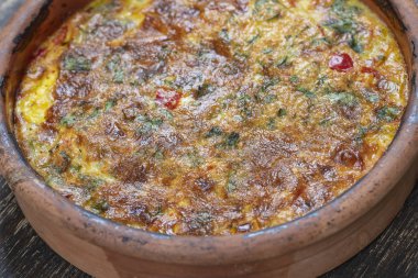 Sebze frittata, basit vejetaryen gıda ile Seramik kase. Ahşap masa üzerinde domates, biber, soğan ve peynir ile Frittata, yakın. İtalyan yumurtalı omlet
