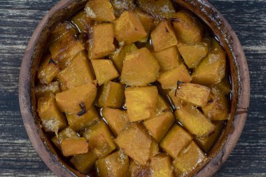 Ahşap masa üzerinde bir tabak üzerinde bal, zeytinyağı ve baharat ile pişmiş sarı kabak. Vejetaryen yemekleri. Closeup