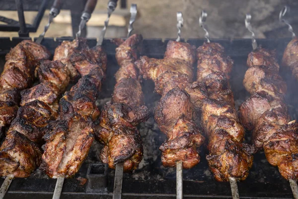 Grilled kebab cooking on metal skewer closeup. Roasted meat cooked at barbecue. BBQ fresh beef meat chop slices. Traditional eastern dish, shish kebab — Stock Photo, Image