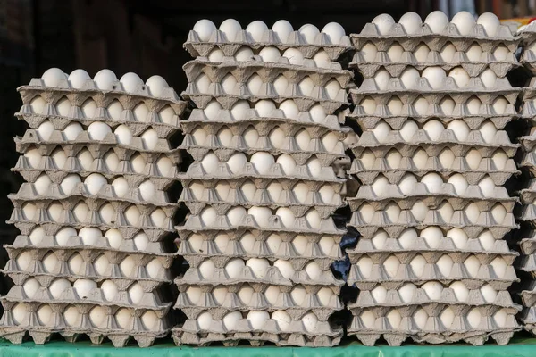Stacks of white eggs in trays on local street market in India