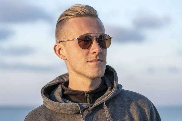 Retrato de un joven descansando cerca del mar en la playa, otoño, de cerca — Foto de Stock