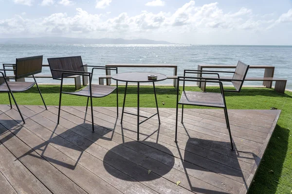 Houten tafel en stoelen in een leeg strandcafé naast zeewater. Eiland Koh Phangan, Thailand — Stockfoto