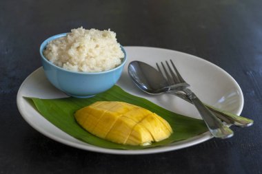 Tay tarzında tatlı, plaka üzerinde yapışkan pirinç ile mango. Sarı mango ve yapışkan pirinç olduğunu Tayland popüler geleneksel tatlı