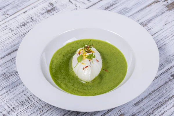 Grüne Sauce mit pochiertem Ei in weißem Teller, Nahaufnahme — Stockfoto