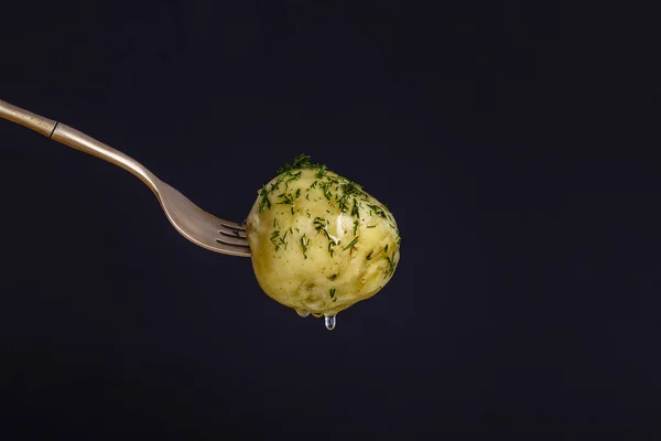 Potatis på en gaffel med svart bakgrund — Stockfoto