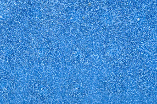 Ondas de água no fundo da piscina azulejos azul. Vista superior — Fotografia de Stock