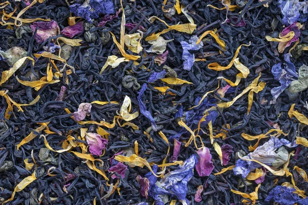 Chá de ervas secas com pétalas de frutas e flores como fundo, vista superior — Fotografia de Stock