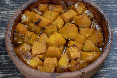 Ahşap masa üzerinde bir tabak üzerinde bal, zeytinyağı ve baharat ile pişmiş sarı kabak. Vejetaryen yemekleri. Closeup