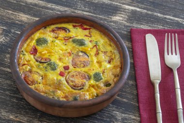 Sebze frittata, basit vejetaryen gıda ile Seramik kase. Yumurta, domates, biber, soğan, brokoli ve peynir ile frittata ahşap masada. İtalyan yumurtalı omlet