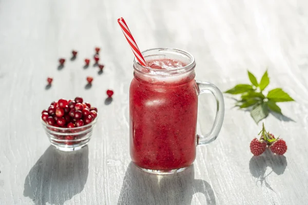Batido rojo orgánico fresco en taza de vidrio sobre mesa blanca, de cerca. Refrescante bebida de frutas de verano. El concepto de alimentación saludable. Batido de arándanos y frambuesas — Foto de Stock