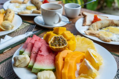 Otel restoranında, Zanzibar adasında, Tanzanya 'da, Afrika' da, deniz kenarındaki sahilde, meyveli, kahveli ve muzlu gözlemeli tropik kahvaltı.