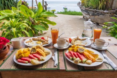 Otel restoranında, Zanzibar adasında, Tanzanya 'da, Afrika' da, deniz kenarındaki sahilde, meyveli, kahveli ve muzlu gözlemeli tropik kahvaltı.
