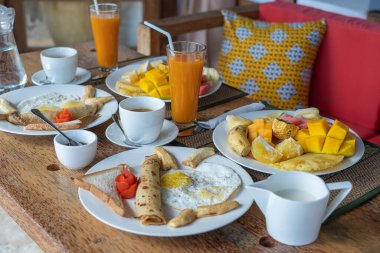 Otel restoranı, Zanzibar adası, Tanzanya, Afrika 'da deniz kenarındaki plajda iki kişilik meyve, kahve ve muzlu krep. Üst görünüm, tablo ayarı.