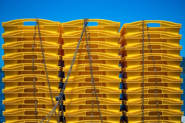 运输塑料容器 黄色盒子堆在蓝天背景上 马来西亚科塔基纳巴卢港口城市 一个金属链条连接的用于运送鱼类的塑料盒被关闭 — 图库照片