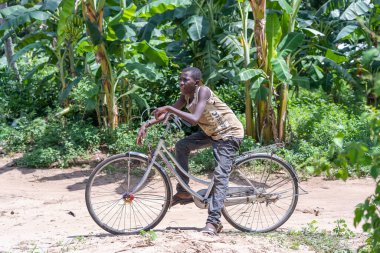 Zanzibar, Tanzanya - 16 Kasım 2019: Güneşli bir günde Tanzanya, Doğu Afrika 'daki Zanzibar adasında bisiklet süren tanınmamış Afrikalı adam,