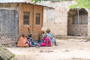 Zanzibar, Tanzanya - 16 Kasım 2019: Afrikalı kadın ve çocuklar Zanzibar Adası, Tanzanya, Doğu Afrika yakınlarındaki sokakta oturuyorlar