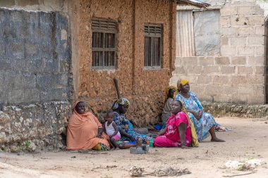 Zanzibar, Tanzanya - 16 Kasım 2019: Afrikalı kadın ve çocuklar Zanzibar Adası, Tanzanya, Doğu Afrika yakınlarındaki sokakta oturuyorlar