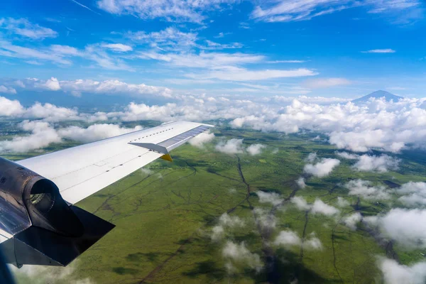 地球の上とタンザニア 東アフリカの領土で雲の上を飛んでいます 飛行機の窓からの眺め 飛行機は地球の上の空を飛ぶ — ストック写真