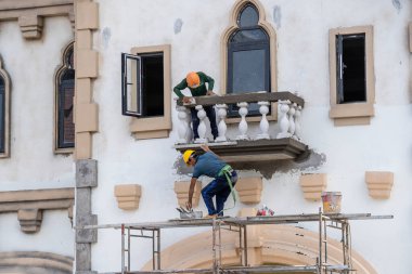 Phu Quoc Adası, Vietnam - 25 Mayıs 2020: İki Vietnamlı inşaatçı Phu Quoc Adası, Vietnam 'da bir binanın ön cephesine balkon yerleştirdi