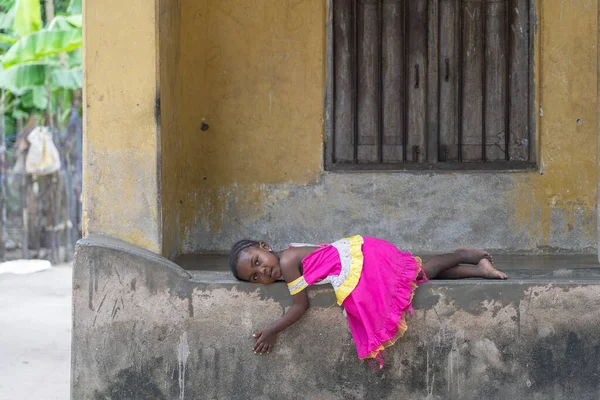 Zanzibar, Tanzanya - 30 Ekim 2019: Tanzanya, Doğu Afrika 'daki Zanzibar adasındaki evin verandasında kimliği belirsiz Afrikalı genç bir kız yatıyor