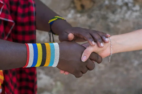 Masai tribal man with a caucasian girl making a handshake in the street on the island of Zanzibar, Tanzania, East Africa, close up