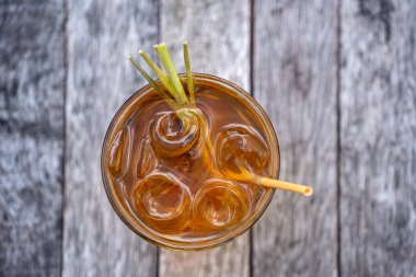 Healthy, refreshing drink of cinnamon and stalks of lemongrass on a wooden table, top view, close up clipart