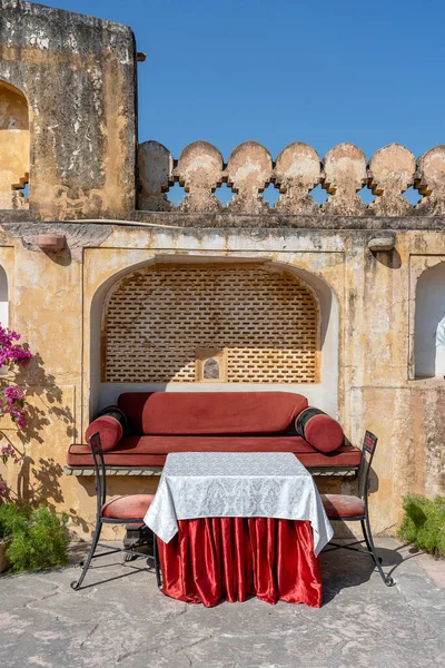 Street cafe in old town, outside in Jaipur, Rajasthan, India. Table, sofa and chairs near old wall, close up