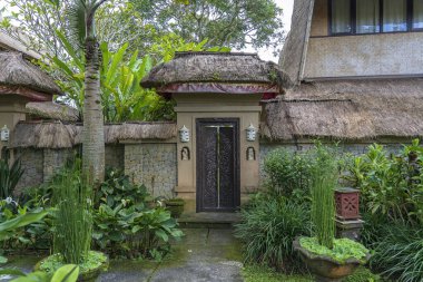 Kaldırımlar, Endonezya, Bali, Ubud, Ubud gibi tropikal bir bahçede Balili heykellerin bulunduğu bir eve açılıyor.