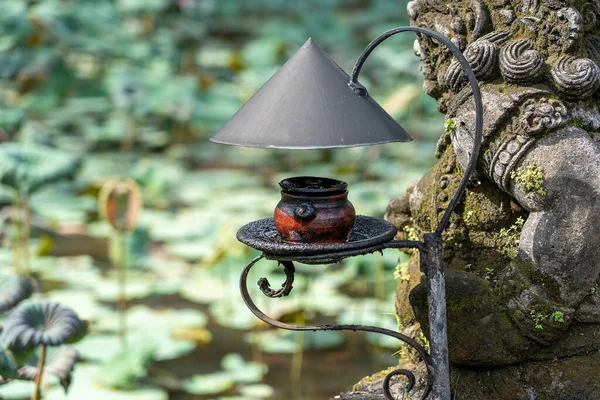 Vintage kerosene lamp as gardening decoration. Tropical asian natural style in island Bali, Indonesia. Old vintage kerosene lamp in garden. Unusual decoration in Bali luxury outdoor style. Close up