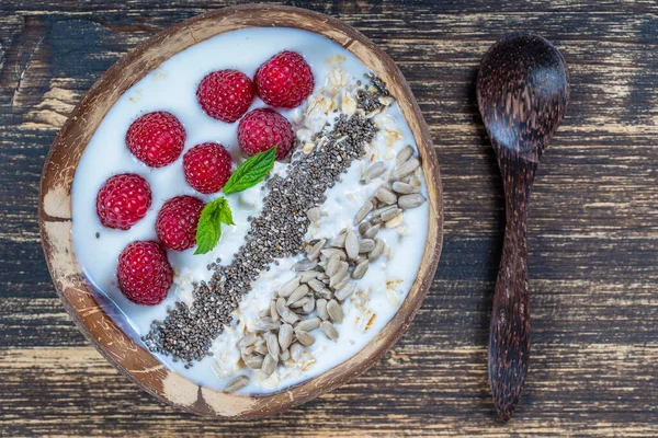 在椰子碗中加入覆盆子 葵花籽和奇亚种子作为早餐 健康饮食的概念 超级食物 顶部视图 — 图库照片