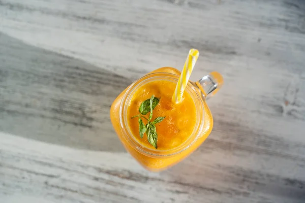 新鲜的有机黄色冰沙在白色木制桌子上的玻璃杯中 让夏季水果饮料焕然一新 健康饮食的概念 有蜂蜜和水的沙棘在阳光充足的日子里 — 图库照片