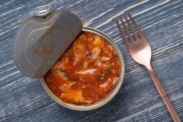 木製の背景にトマトソースで缶詰のスプラットを開く 閉じる 上のビュー — ストック写真