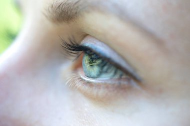 Kafkas sarışının yakından bakan gözü. Genç bir kadının portresi. Kafkasyalı kız arka planda, gözlerini kapat.