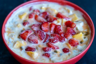 Mango, çarkıfelek meyvesi, kırmızı çilek ve yoğurt. Kahvaltıda meyveli tatlı, mevsimlik mango ve çilekli, taze tutku meyvesi hamuru kaplı, mükemmel olgunlaşmış mangolarla.