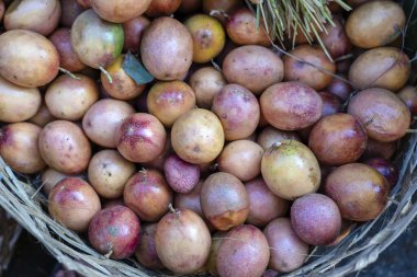 Bambu üzerinde çiğ tutku meyvesi ya da Ubud, Bali, Endonezya 'daki geleneksel sokak pazarında satılmak üzere ahşap sepet.